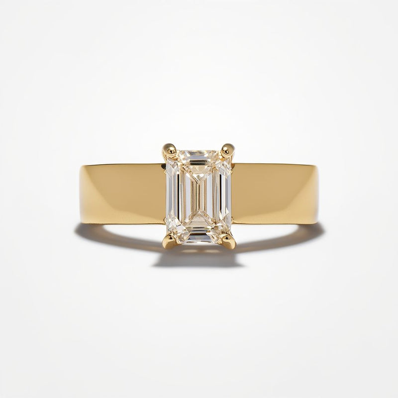 A modern yellow gold solitaire ring featuring a sleek wide band and a vertically set emerald cut diamond from a custom jewelry creator
