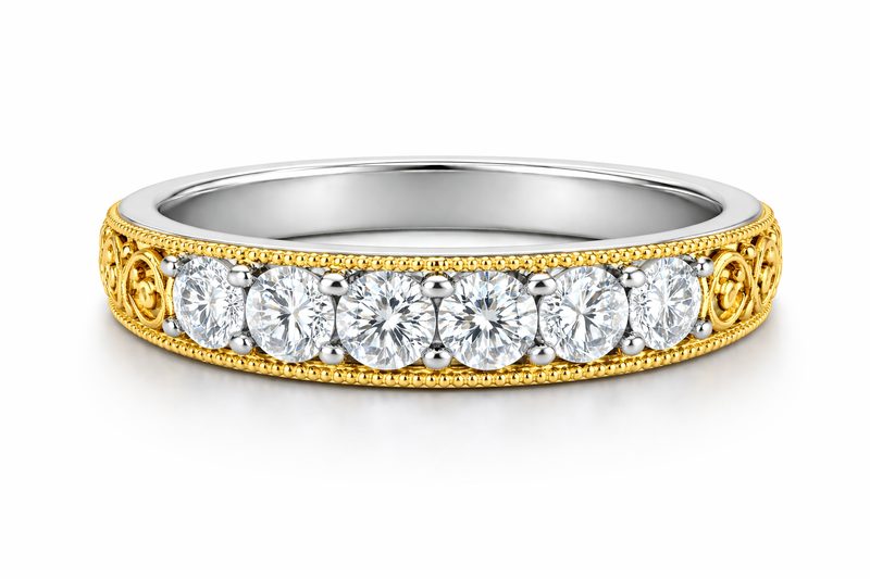 A detailed custom jewelry creator eternity band featuring intricate yellow gold filigree milgrain borders and large white gold prong set round diamonds
